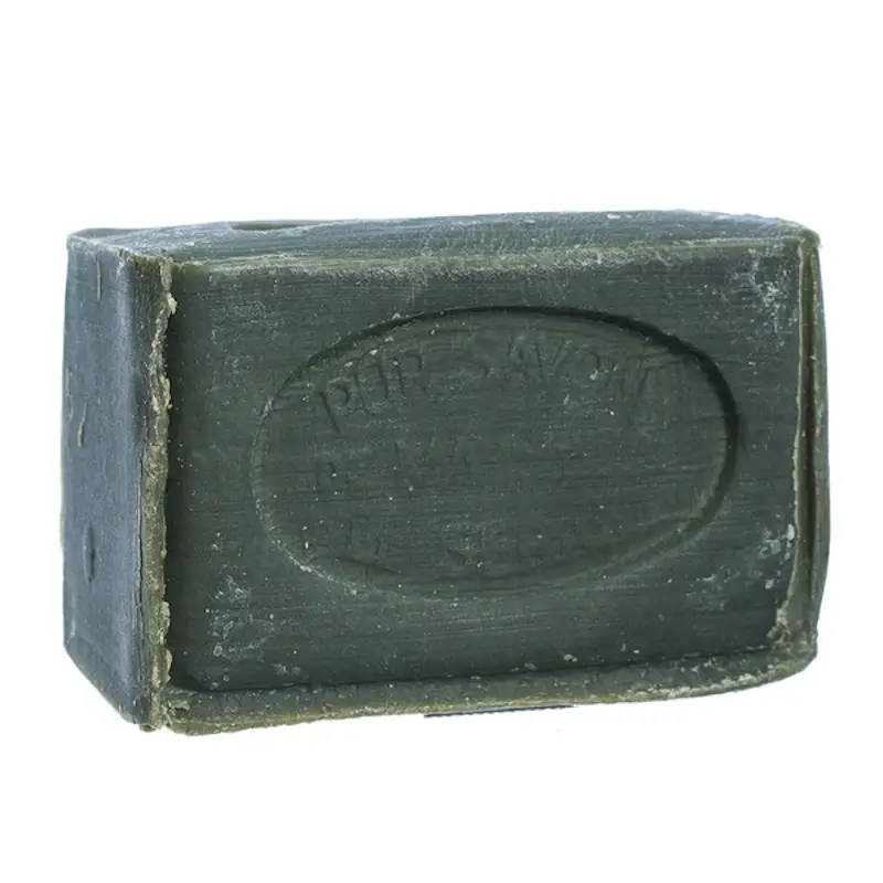 A block of hypoallergenic soap made by savon de marseille. This soap is a really dark green color, and looks handmade.