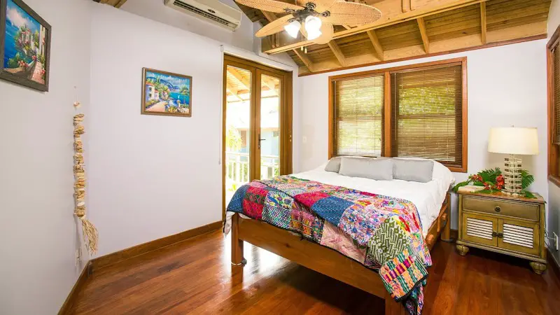 A beach vacation rental bedroom with a bed and nightstand.