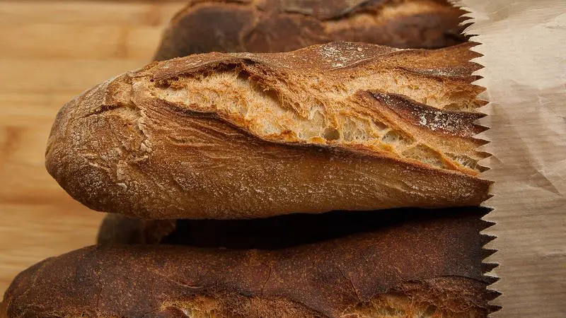 loaf of barley or rye bread in a paper bag