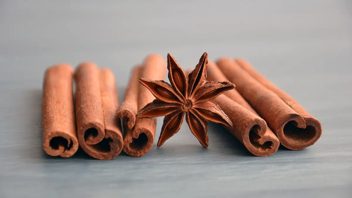 Rolls of cinnamon bark, dried on a table, with a star seed pod in the middle of the cinnamon sticks. is cinnamon a nut allergy?