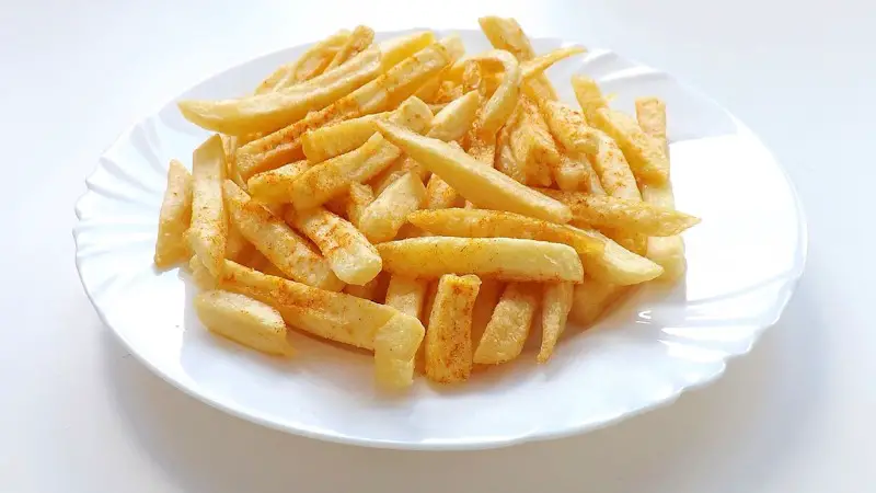 A plate of seasoned french fries.