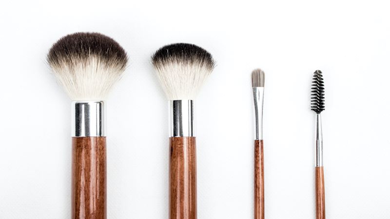 four makeup brushes with various lengths and functions.