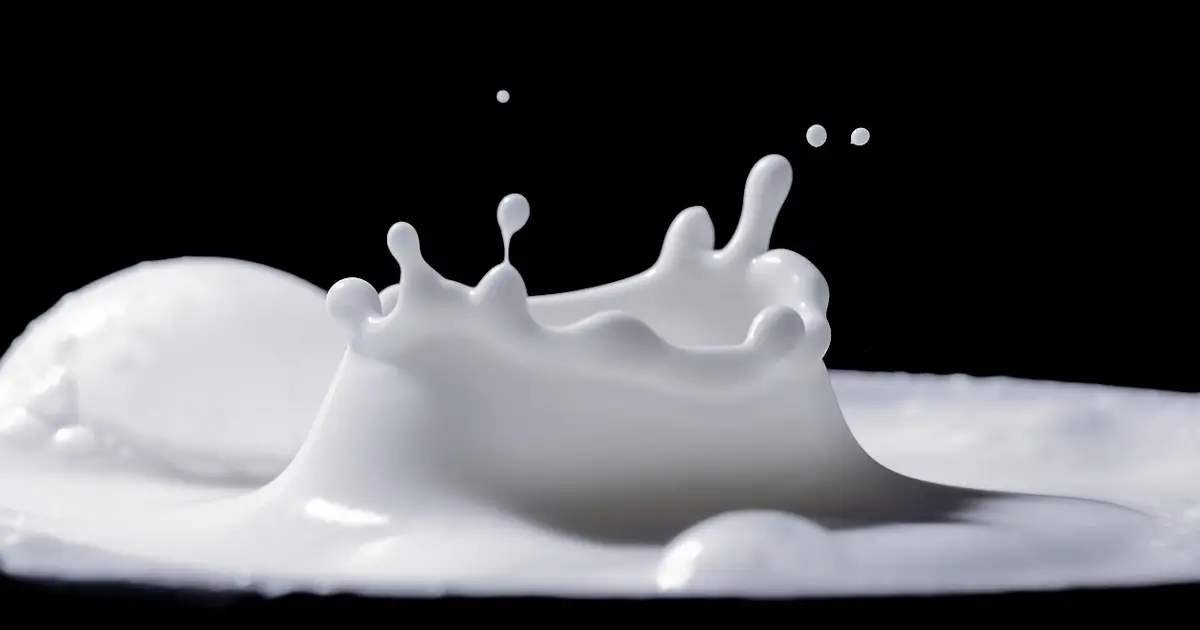 Cow's milk splashing into a cup.