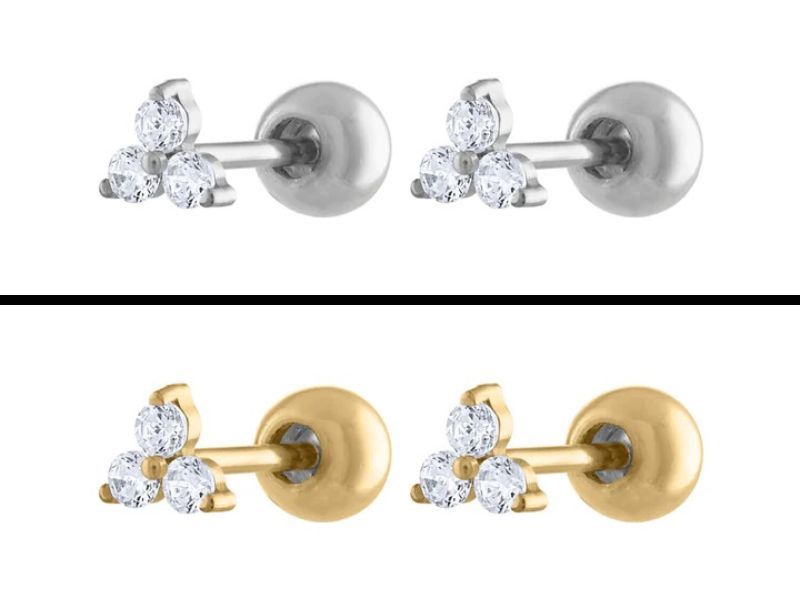 Two pair of titanium stud earrings called the mini crystal trinity studs. Each earring contains three crystals in the shape of a trinity star. Earring colors are silver and gold.