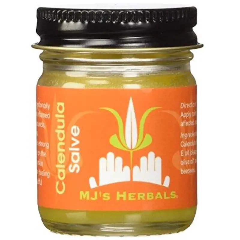 A jar of MJ's Herbals® Calendula salve which is in a glass container, and a metal lid.
