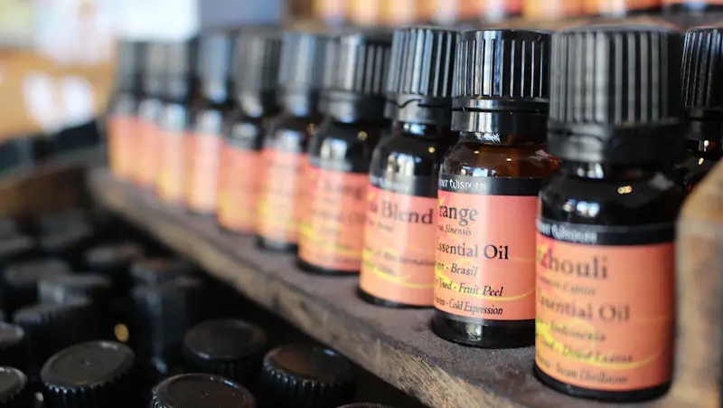 a wooden board filled with many bottles of essential oils with an orange label.