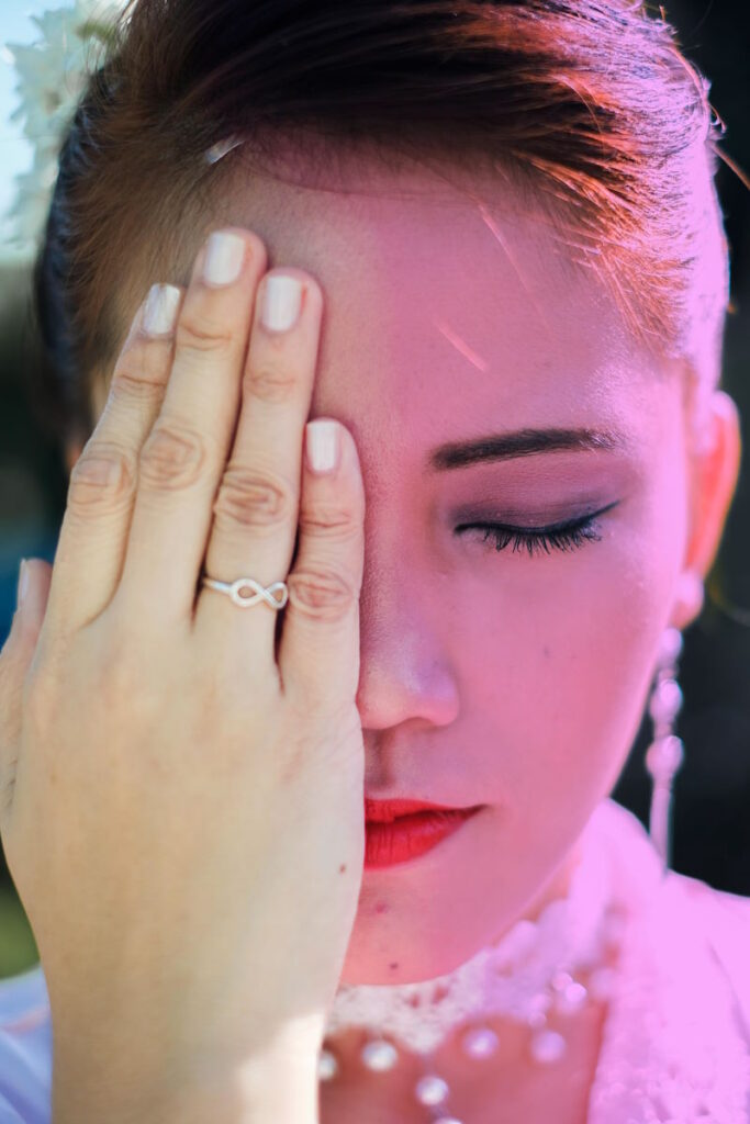 Woman covering her right-side of her face with her hand, and receiving UV photosensitivity treatment on the left side of her face.