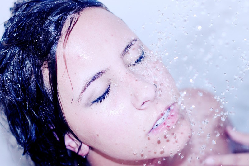 lady in the shower with the water hitting her face.