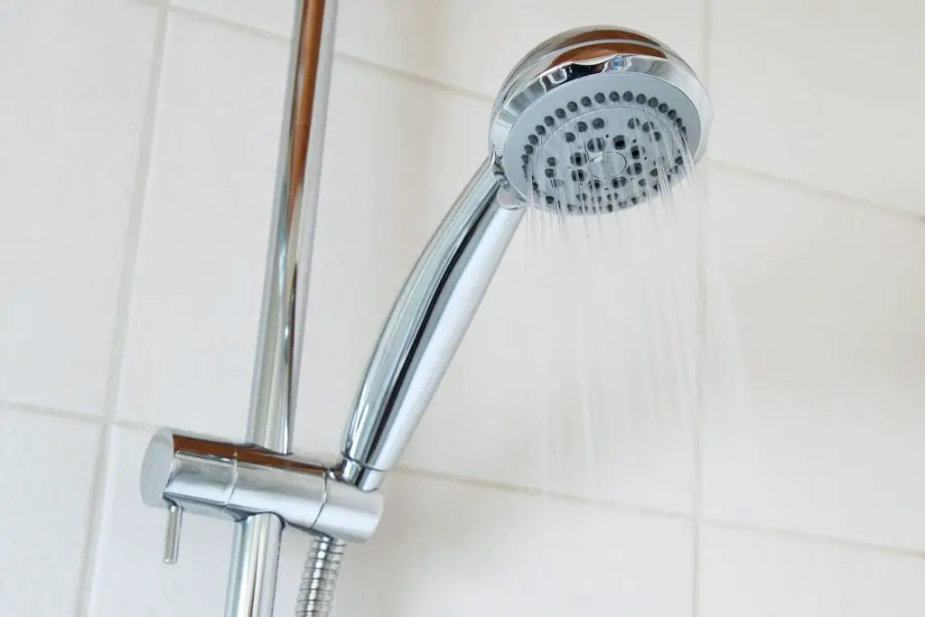 a chrome shower head with the water running